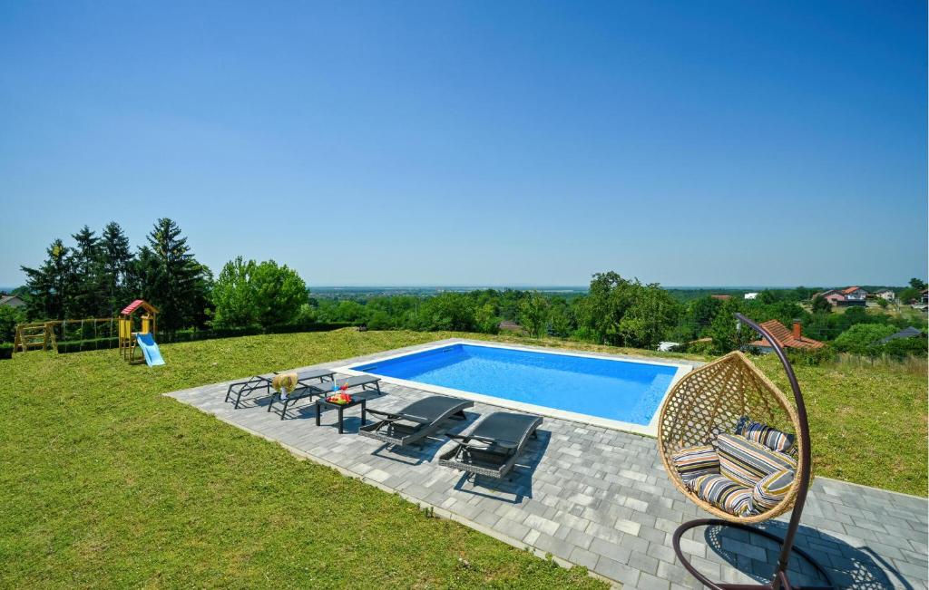 a swimming pool in a yard with chairs at Modern Home With Pool And View in Popovača