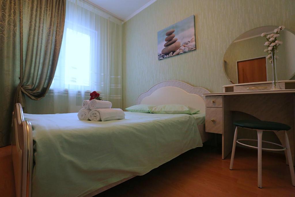 スルグトにあるSurgut Apartments Apartments on Tumenskiy Tract 2 Auraのベッドルーム(ベッド1台、デスク、鏡付)