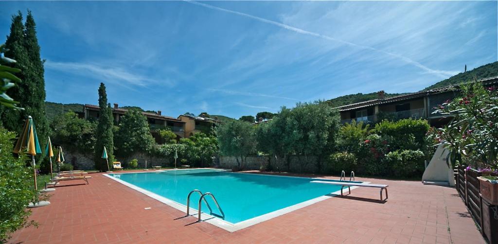 a large swimming pool in a yard with a building at Nisportino Domus in Rio nellʼElba