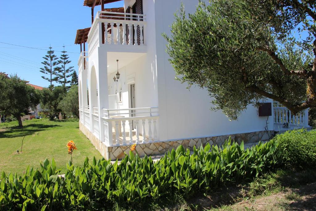 una casa bianca con balcone e alcune piante di Explorer's Rest ad Argásion
