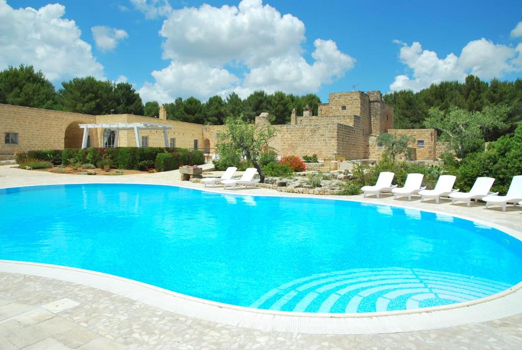 サンニコーラにあるMasseria Relais Santa Teresaの大きなスイミングプール(ラウンジチェア付)