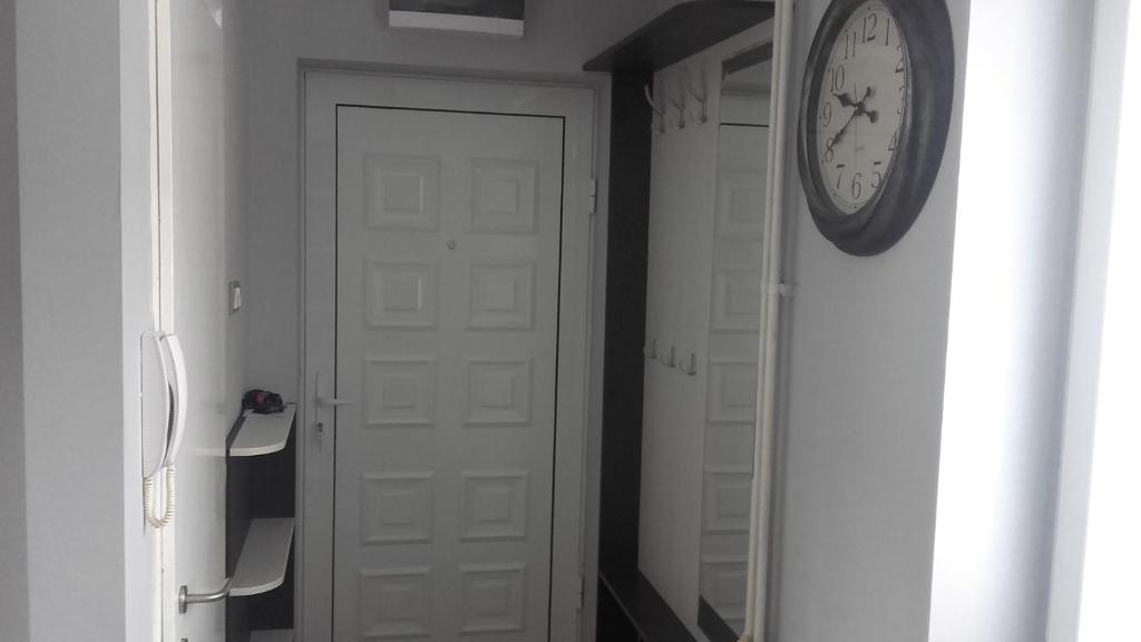 eine Uhr an einer Wand neben einer weißen Tür in der Unterkunft House Prljevic in Užice