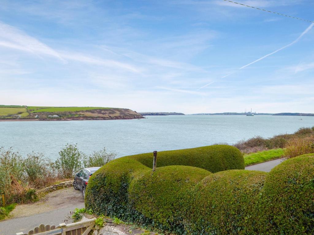 a car parked on a road next to a body of water at Cliff Cottage - Uk43207 in Dale