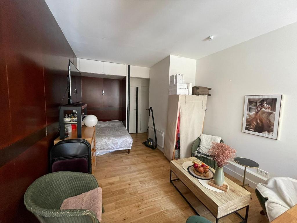 un salon avec un canapé et un lit dans l'établissement Studio cosy Josy, à Paris