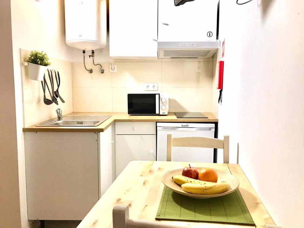 a kitchen with a table with a plate of fruit on it at e5túdio frt in Peniche