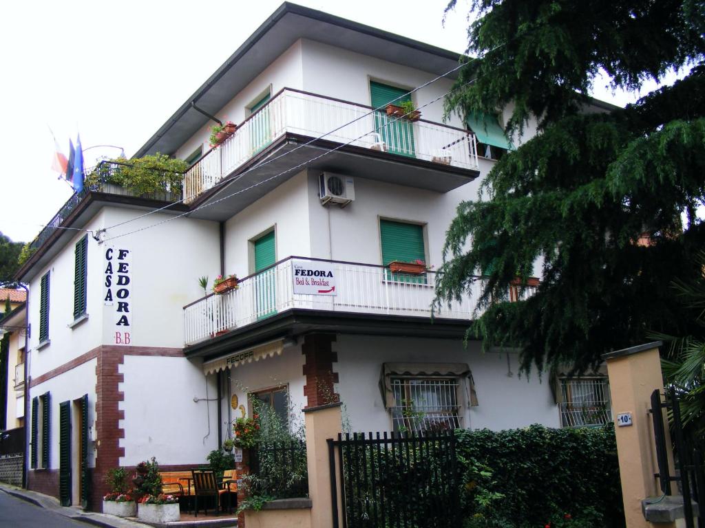 - un bâtiment blanc avec balcon dans une rue dans l'établissement B&B Casa Fedora, à Montecatini Terme