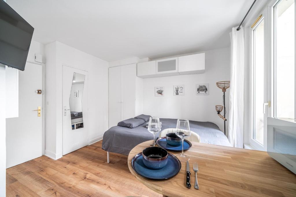 un salon avec une table et un lit dans l'établissement Studio Daguerre - Montparnasse Paris 14th, à Paris