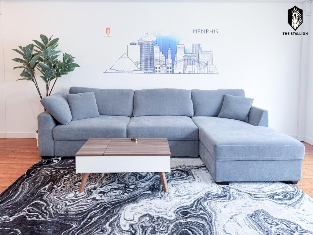Sofá azul en la sala de estar con mesa de centro en The Stallion #204 - Modern Spacious 1BD Loft - Close to Attractions, en Memphis