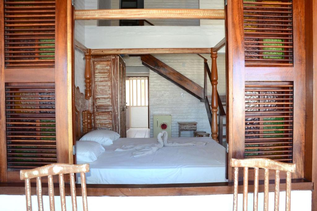 a bedroom with a bunk bed with two chairs at Pousada Lua Vermelha in Caponga