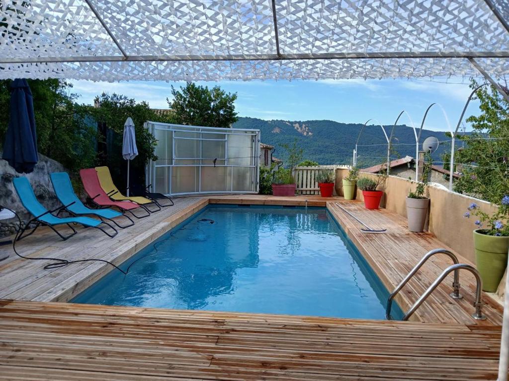 - une piscine sur une terrasse avec des chaises dans l'établissement Au coeur de la haute Provence, à Saint-Julien-dʼAsse