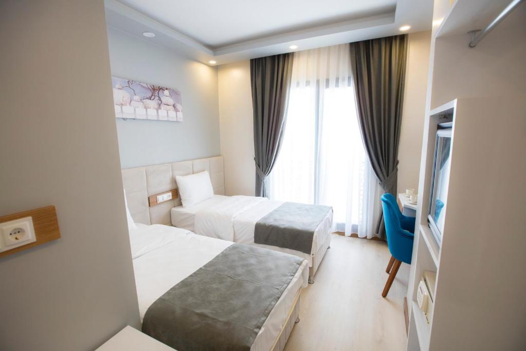 a hotel room with two beds and a window at Royal İnci Hotel in Istanbul