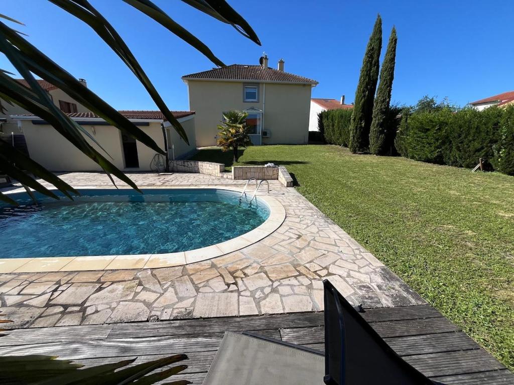 a swimming pool in a yard next to a house at appartement tout confort dans villa avec piscine in Cébazat