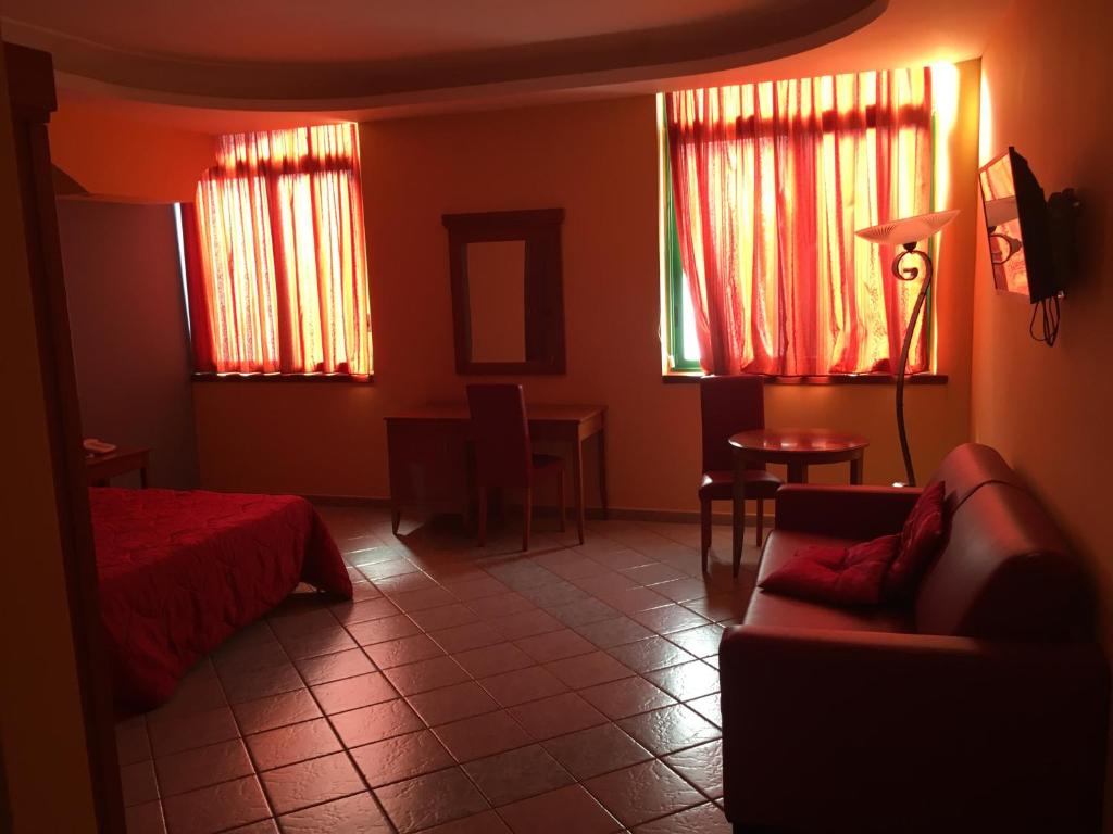Pokój z łóżkiem, kanapą i oknami w obiekcie Hotel Stefano a Melito w mieście Melito di Napoli