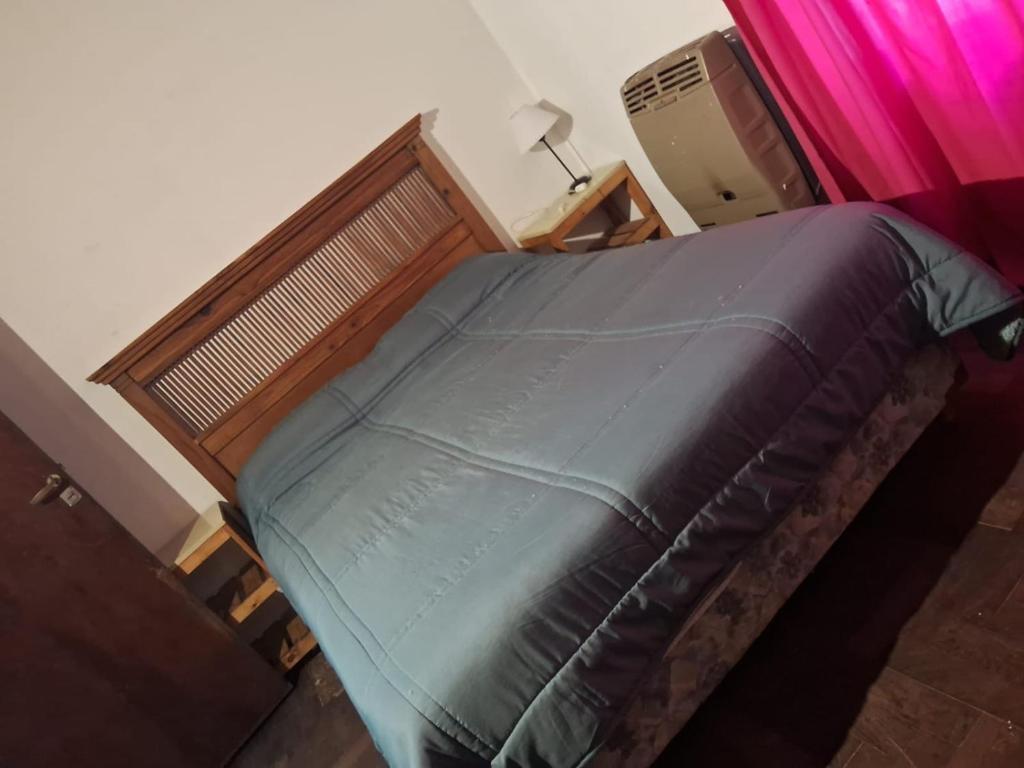 ein Schlafzimmer mit einem Bett mit Holzrahmen in der Unterkunft casa en escobar con cocheras in Belén de Escobar