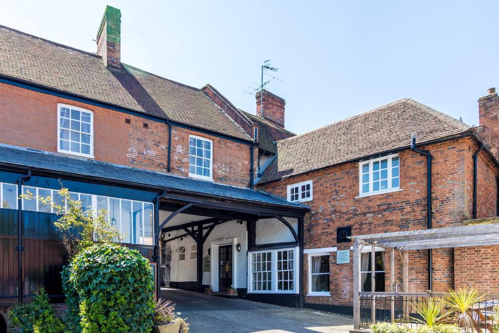 a group of old brick buildings with a garage at The White Hart Hotel in Welwyn