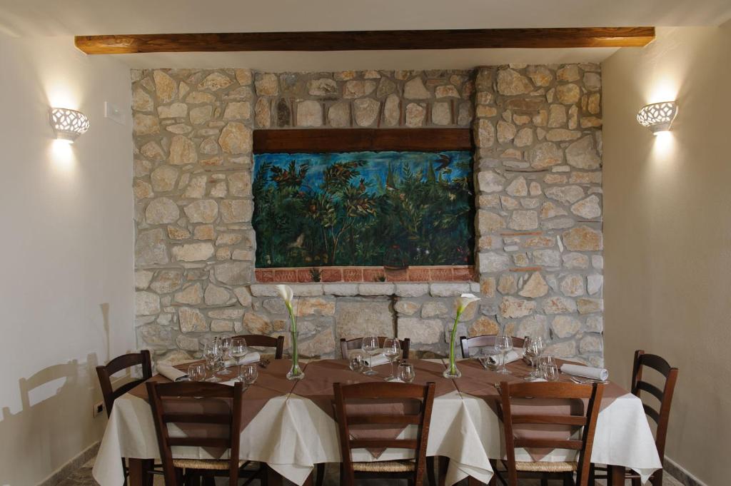 uma sala de jantar com uma mesa e uma parede de pedra em Domus Otium em Atena Lucana