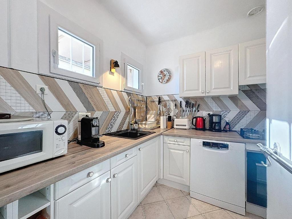 une cuisine avec des armoires blanches et un micro-ondes dans l'établissement Villa for 4 people with WiFi, parking, and garden, à Saint-Raphaël