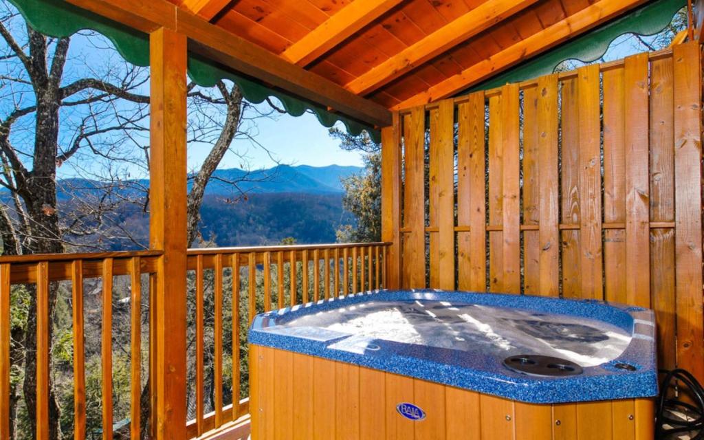 una vasca idromassaggio su una terrazza in legno con finestra di Bear Tracks a Gatlinburg