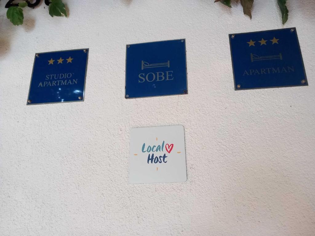 un groupe de signaux sur une paroi dans l'établissement Guest House Green Corner Supetarska Draga - Studio Apartment with Terrace And Sea View, à Rab