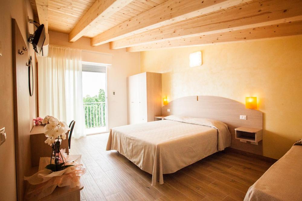 ソットマリーナにあるAlbergo Parisのベッドルーム(大型ベッド1台、大きな窓付)