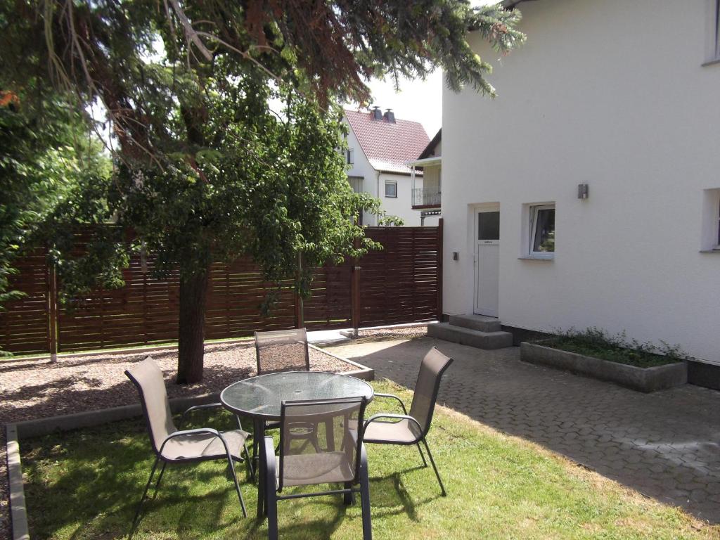 un patio con mesa y sillas bajo un árbol en Fewo-Knaus en Holzminden