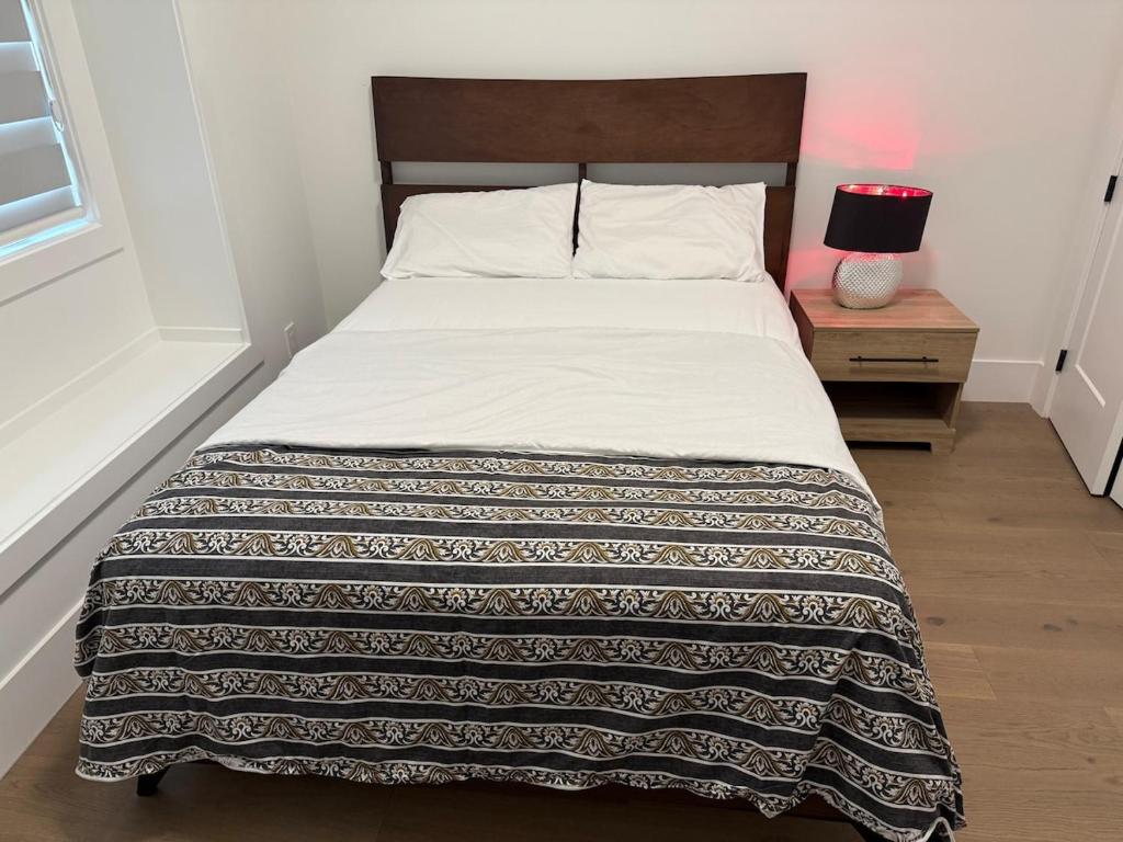 a bed with a blanket on it in a bedroom at Calm & Cozy Private Suite in Surrey
