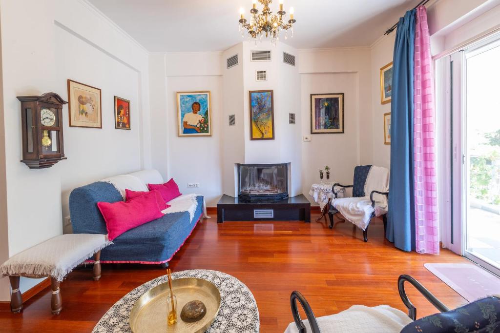 Una sala de estar con un sofá y un televisor. en Virginia's Art House, en Porto Rafti