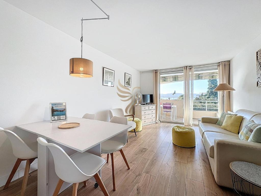 un salon avec une table blanche et un canapé dans l'établissement Apt 4 ppl, terrace, pool, A/C, à Saint-Raphaël