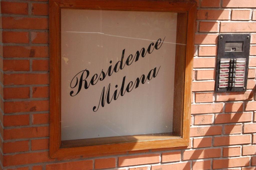 ミラノ・マリッティマにあるResidence Milenaの電話付きのレンガ壁の窓