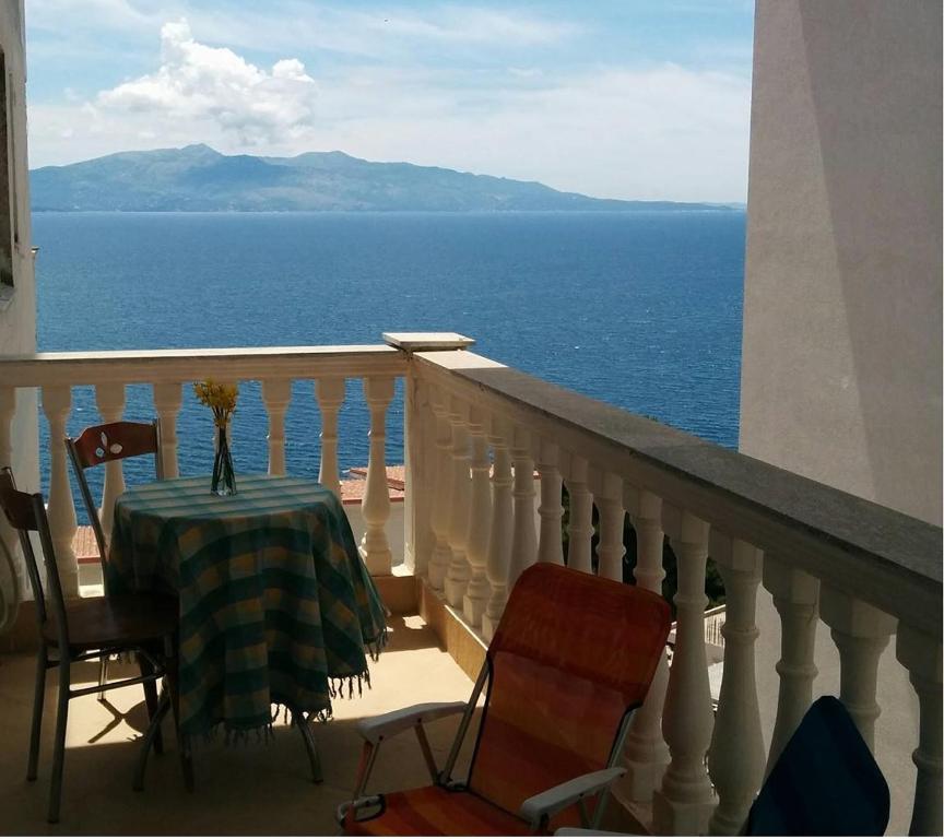 een balkon met een tafel en stoelen en de oceaan bij Sea - you apartment in Sarandë