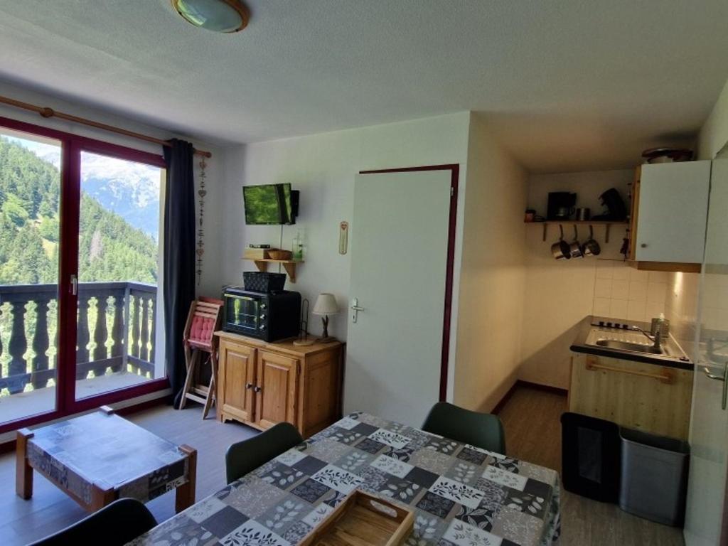 une chambre avec une table et une cuisine avec un balcon dans l'établissement Appartement 6 pers à Valfréjus, près des pistes, avec balcon, parking gratuit et équipements bébé - FR-1-561-104, à Modane