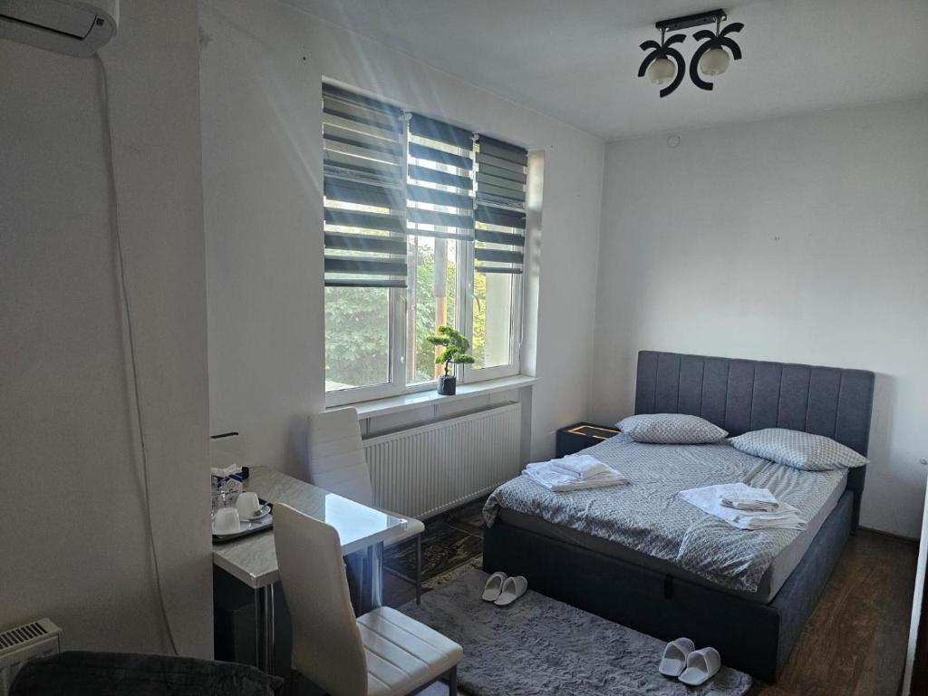 a bedroom with a bed and a desk and a window at SMB home PANORAMA in Oradea