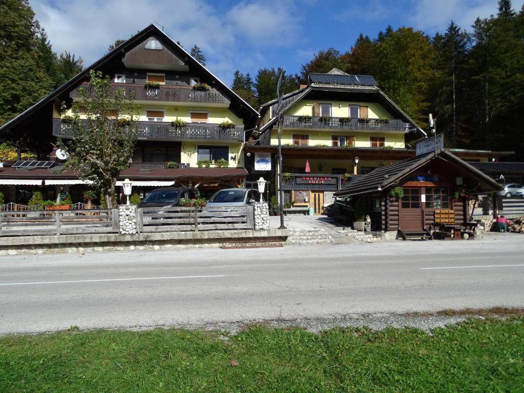 a large building with cars parked in front of it at Penzion Rožič in Bohinj