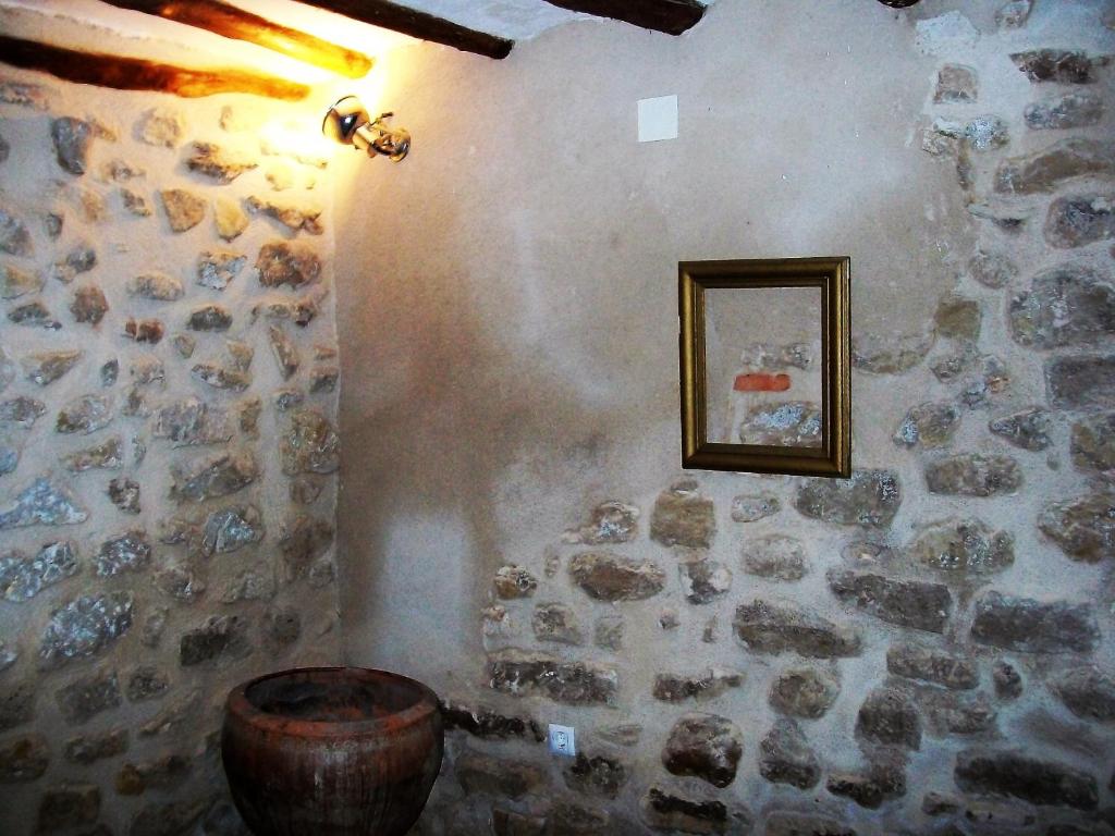 a room with a stone wall with a barrel and a picture at Luna11 in Alcañiz