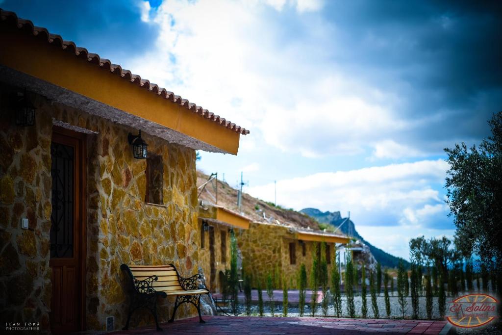 a bench sitting outside of a building with a fence at Casas y Cuevas El Solins in Las Casicas