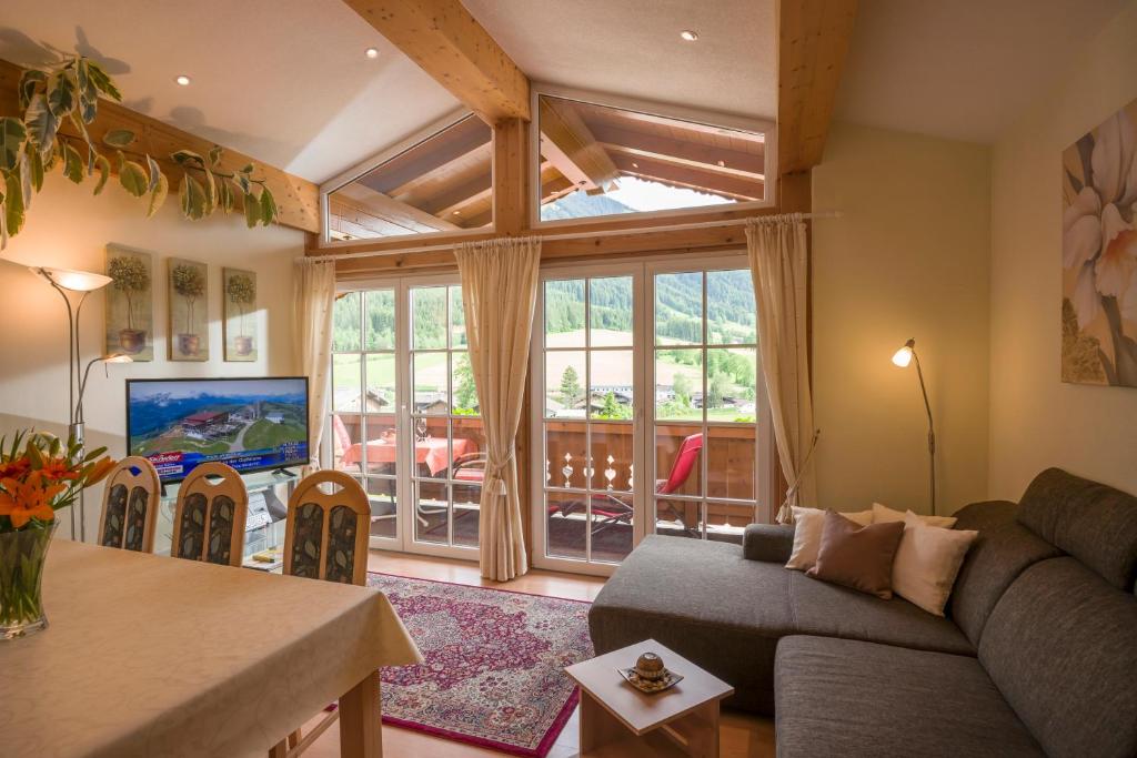 ein Wohnzimmer mit einem Sofa und einem großen Fenster in der Unterkunft Appartement Irmgard in Brixen im Thale