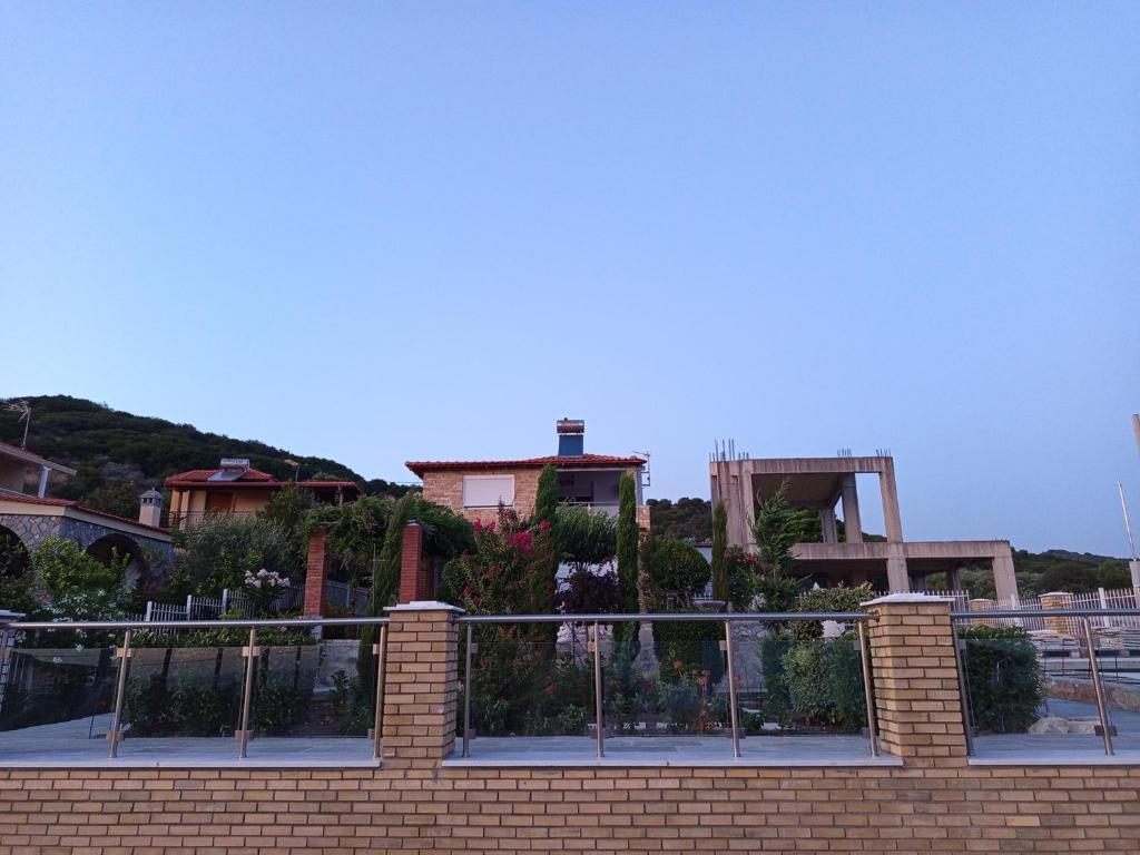 ein Ziegelzaun mit Pflanzen auf einem Gebäude in der Unterkunft Blue Paradise Villa in Karianí