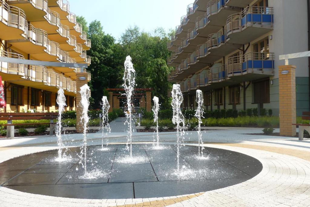 a fountain in a courtyard in front of a building at Apartament z ogródkiem w Parku Zdrojowym in Świnoujście