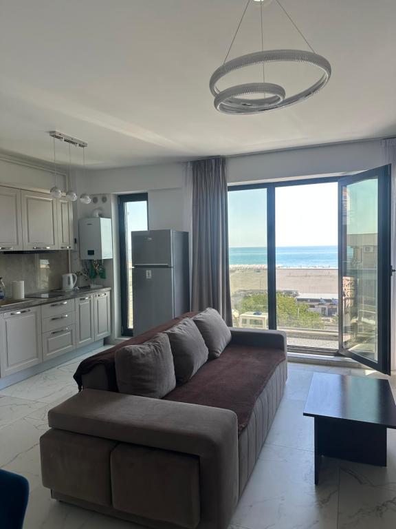 a living room with a couch and a large window at ELIZ Luxury Residence in Mamaia