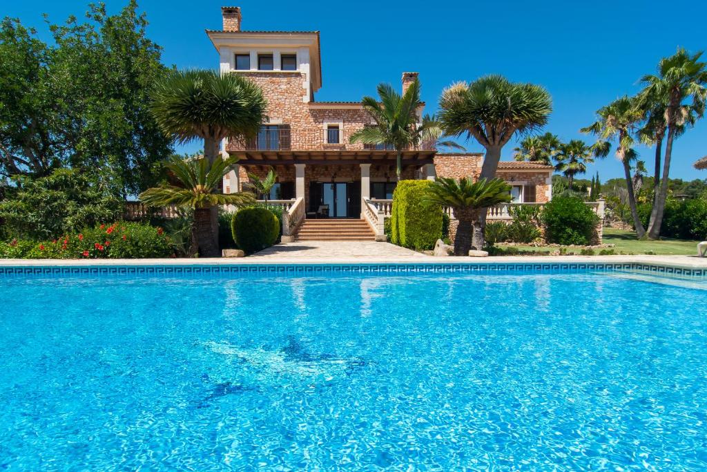 a villa with a swimming pool in front of a house at Can Palleta - Finca para 10 personas en el paraíso in Calonge