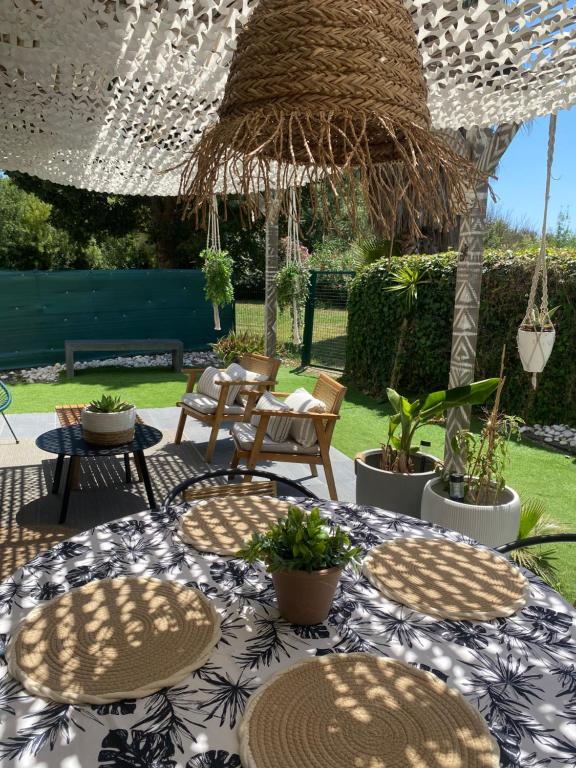 un patio avec une table, des chaises et un parasol dans l'établissement Bel appartement T3 avec jardin Malibu Village, à Canet