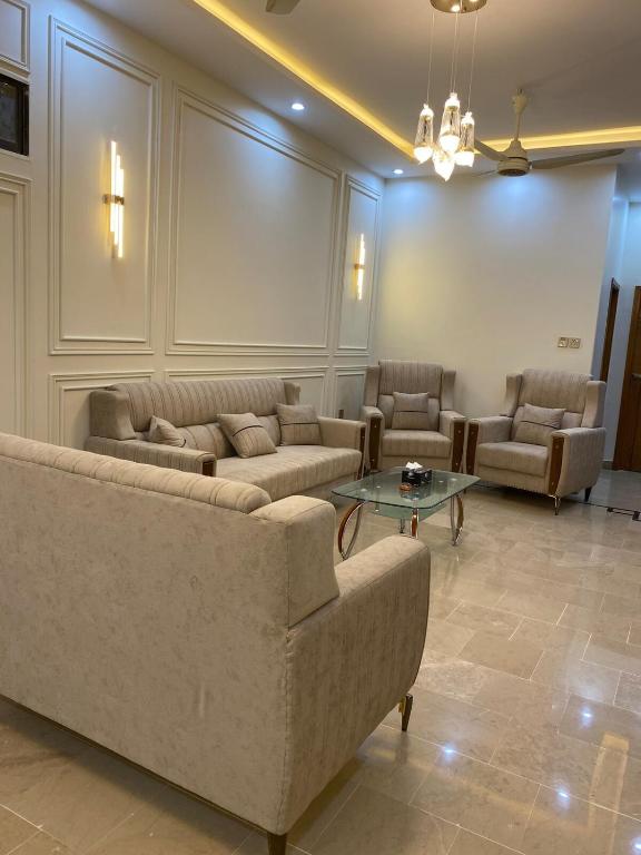 a living room with couches and a table at Johar Guesthouse-Suite 3Bed and Lounge in Karachi in Karachi