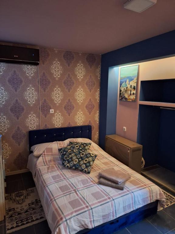 a bedroom with a bed with a plaid bedspread at Dolce Vita in Kraljevo