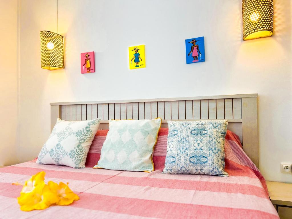a bedroom with a bed with colorful pillows at Lakaz Kreol 2 Soupir Tourist Residence in Port Mathurin