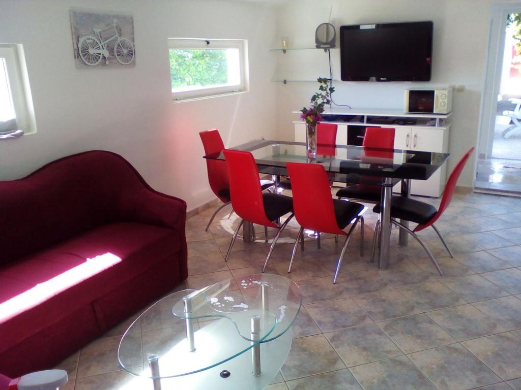 a living room with a couch and a table and chairs at Apartment GRANDE in Preko