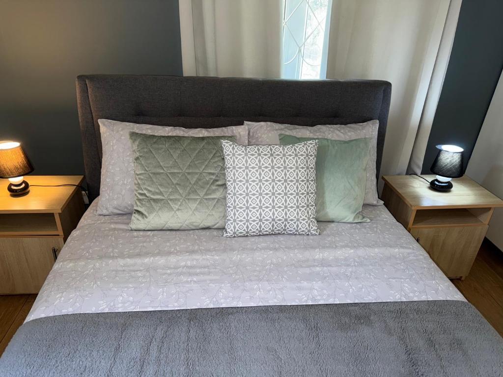 a bedroom with a bed with pillows and two tables at Grand Baie la Croisette villa du bonheur Chez Marie in Hermitage