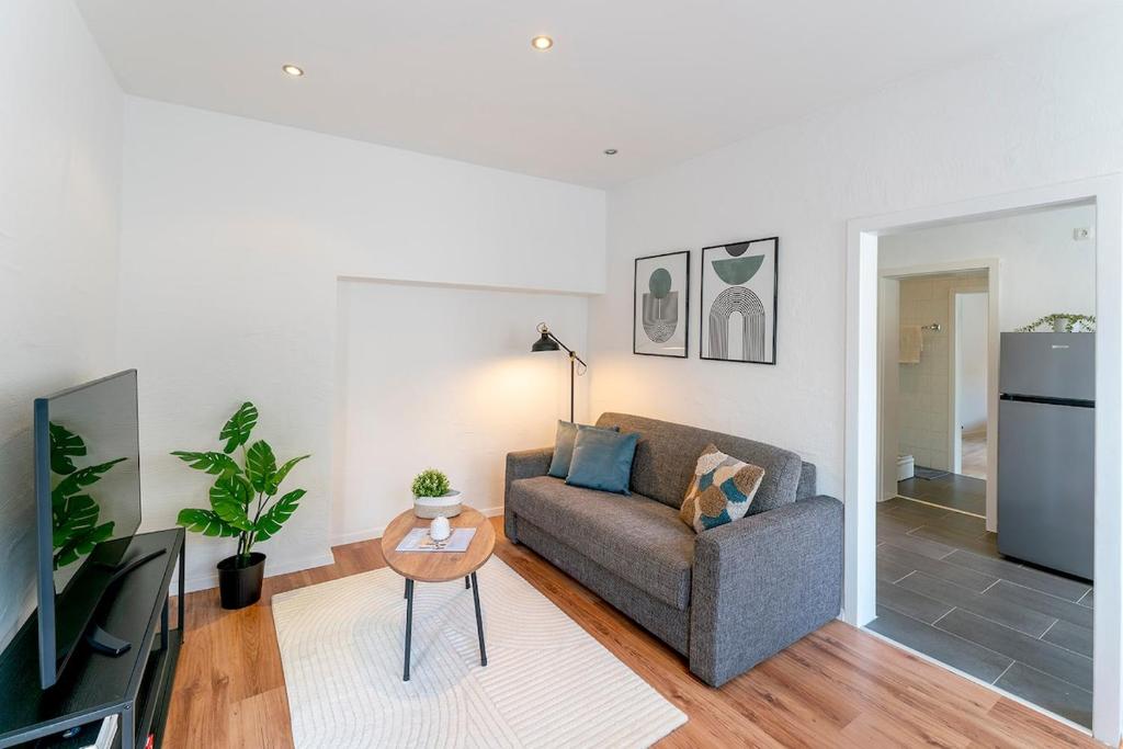 a living room with a couch and a table at Deluxe Koblenz Flat, Parken, Netflix, Ruhig in Bendorf