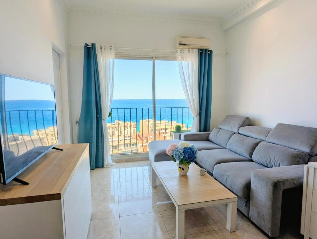 un salon avec un canapé et une vue sur l'océan dans l'établissement Appartement SEA-Azur panorama Nice Fabron, à Nice