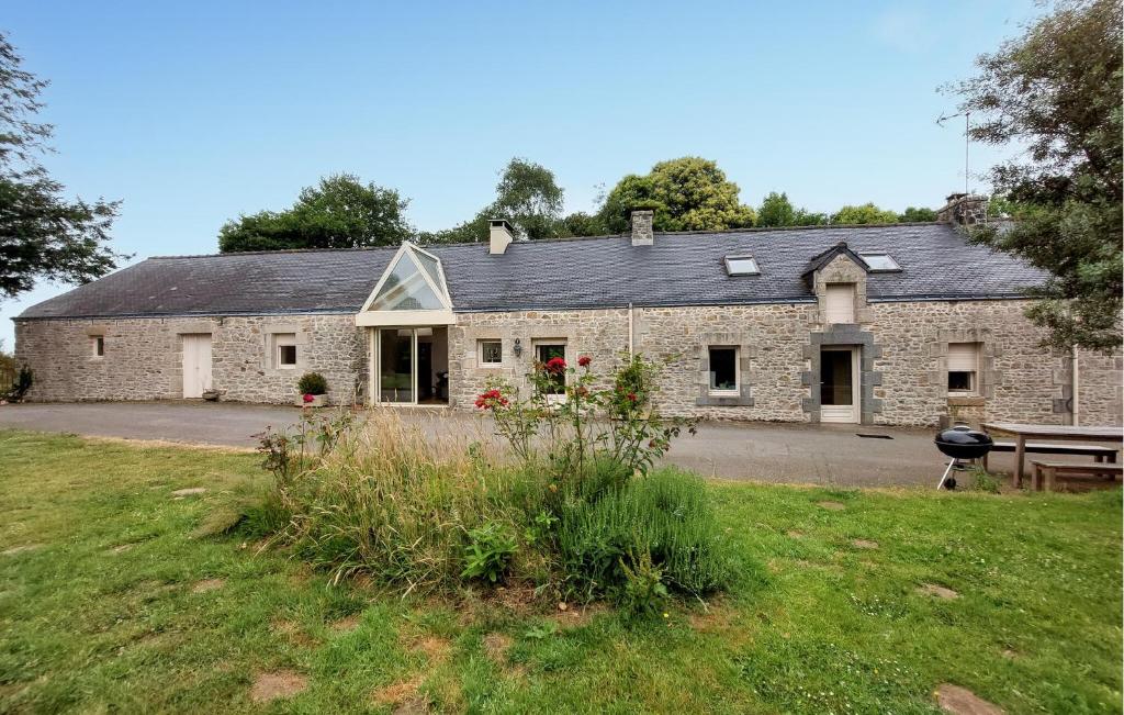 an old stone house with a picnic table in front of it at Grande Longère Bretonne in Silfiac