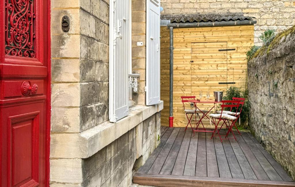 a red door and a patio with a table at Charmante Maison De Ville in Chantilly